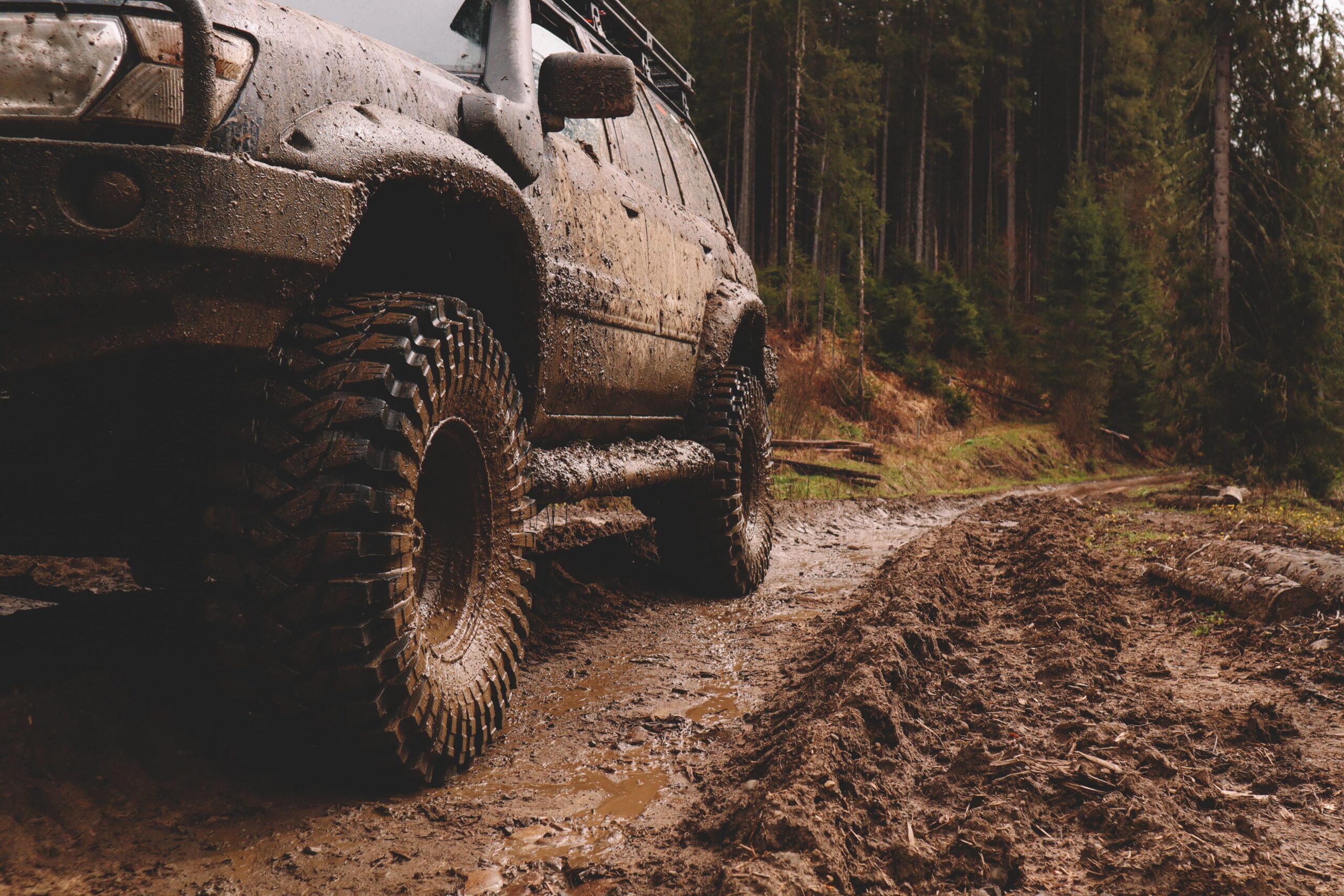 Mud-covered 4x4 on a rutted forest trail - The Best Brakes and Rotors for Off-Road and Towing
